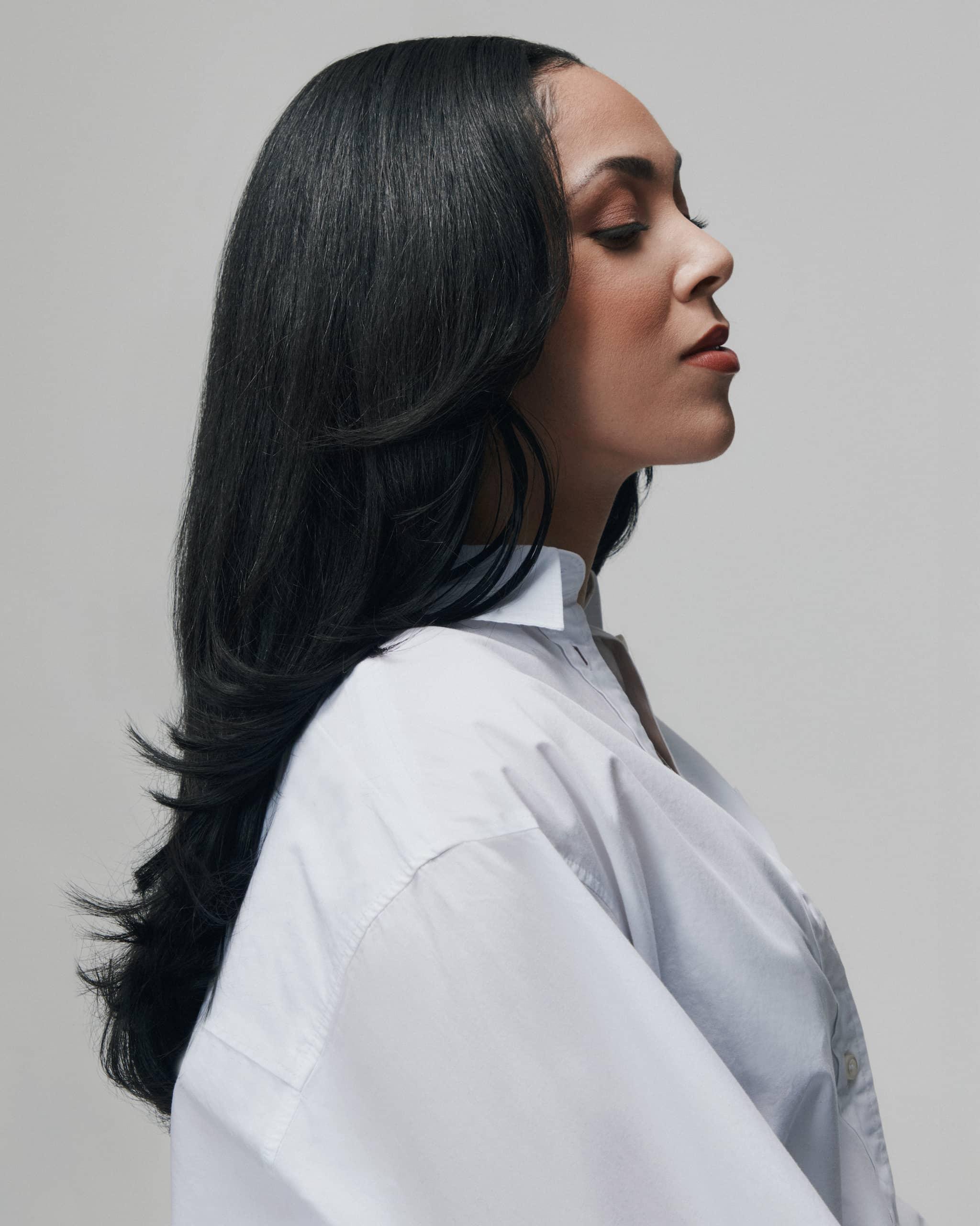 Side view of model wearing 90s Fine raw Vietnamese hair bundles by SOWN, styled with a sleek, straight finish that mimics Type 3 hair texture.
